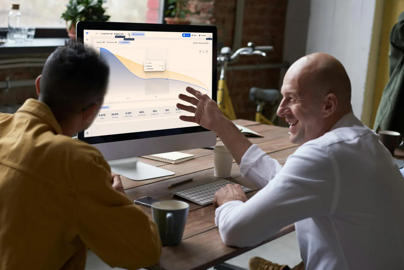 Two people discussing data displayed on a Vidalytics dashboard.